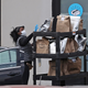 An Amazon Flex driver loads their car with packages outside an Amazon Fulfillment Center.